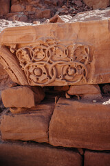 Carved patterns on red sandstone stones. Stones from the walls of the facades of Petra. Jordan. Petra