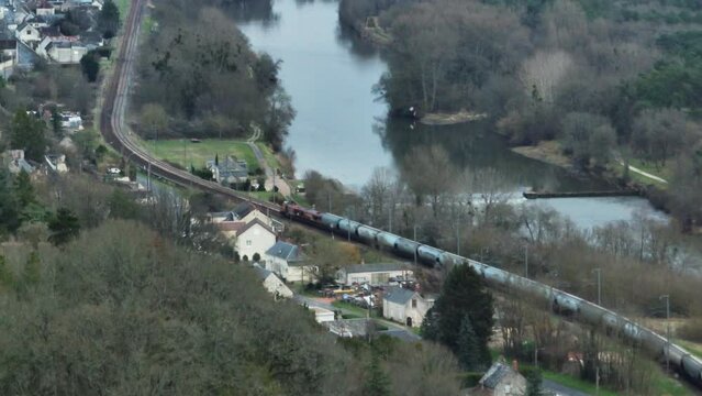 Aerial telephoto shot of a cargo train and car moving in the Loire Valley, France.