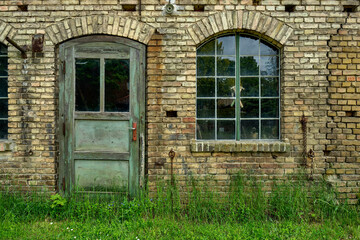 Fototapeta na wymiar Holztür und Sprossenfenster der denkmalgeschützten historischen Schmiede in Prenden