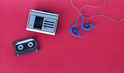 Ein Kassettenabspieler, eine Kassette und Ohrhörer aus den 90er Jahren zum hören von Musik für unterwegs