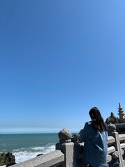 부산 태종대 태종사, 바닷가를 바라보며 서있는 여자의 뒷모습 / Taejongsa Temple in Taejongdae, Busan, the back of a woman standing while looking at the beach