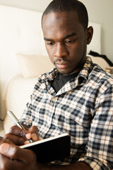 Close up african american man writing in diary book