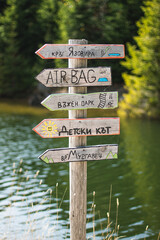 Sign post near lake in the forest.