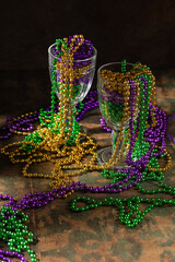 Mardi gras carnivale green, purple, yellow beads on rustic tile background © Ekaterina Senyutina