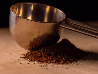 Coffee powder and spoon on a wooden table, close up macro