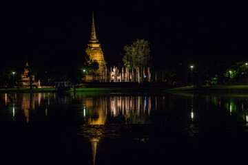 Fototapeta premium Toma nocturna de Buda en Templo de Wat Sa Si, Parque Historico de Sukhothai
