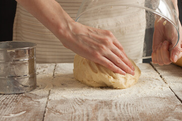 The woman puts the dough on the table