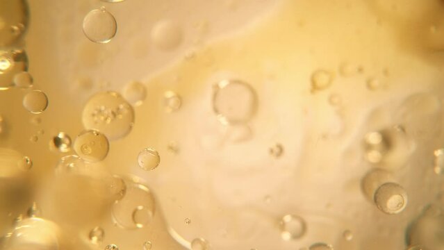 Super Slow Motion Shot of Oil Bubbles on Golden Background at 1000fps. Shoot on high speed cinema camera.
