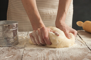 A woman kneads the dough