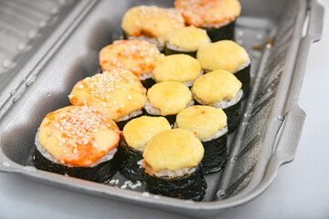 Japanese sushi food, rolls with tuna, shrimp, salmon, crab, avocado, uramaki, hosomaki and nigiri. Assorted different rolls in plastic packaging.