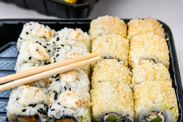 Bamboo sticks for sushi in a set. Various rolls, maki, nigiri in assortment in plastic packaging.