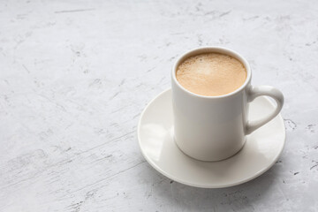 A cup of espresso on a gray background.