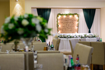 Wedding table decoration with the flowers and greenery in the restaurant