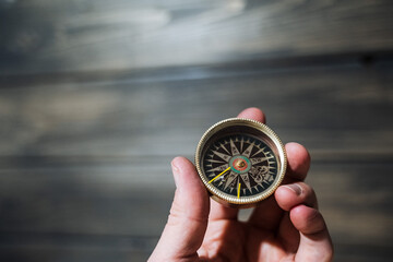 Antique compass in hand. a device that facilitates travel. Orientation to the magnetic poles of the...