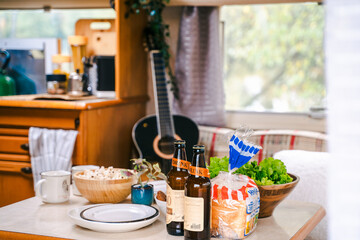 Family traveling in camper. Inside house on wheels,trailer,motor home. Dinner table.Food,guitar. Romantic road travel,freedom life.Campsite overnight,van parking.Wanderlust vacation,weekend adventure