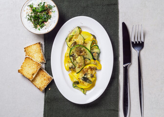 Fried zucchini with melted cheese, herbs and garlic