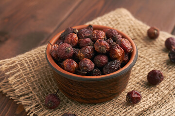 dried dog rose hips rosehip in a bowl on brown background