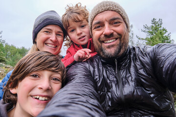 A happy family is relaxing and taking selfie in the mountain