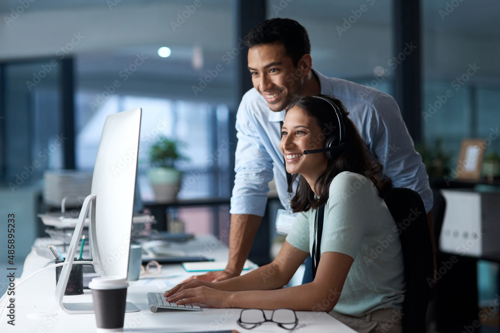 Poster the customer management dream machine. shot of a young man and woman using a computer while working 