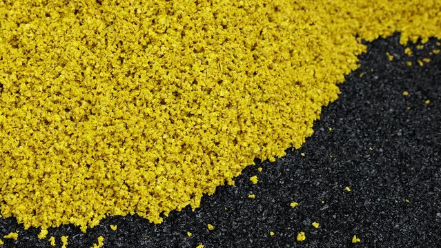 Rubber coating for playgrounds applied on the surface by a steel roller tools. PDM rubber granules. Floor covering for sports. Rubber mulch for safety and injury prevention. Selective focus.