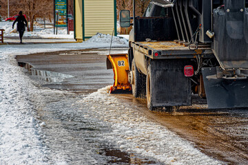 A truck with a snowplow cleans the paved walking paths along the Vestal Rail Trail in Upstate NY of...