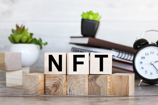 NFT text on wooden blocks on a wooden background