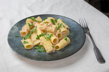 Plate of macaroni with tuna and butter with parsley.