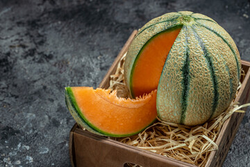 cantaloupe melon. whole and slice of japanese melons, orange melon with seeds on dark background. place for text, top view