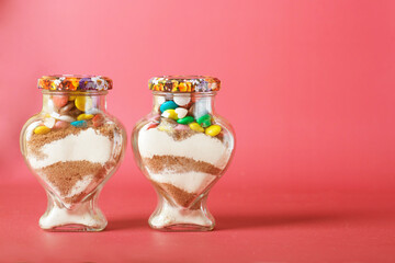 glass jar on a pink background. Dessert for Valentine's Day.