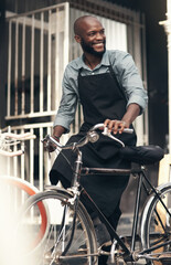 Im the citys best bike salesman. Shot of a handsome young man moving a bicycle from his shop during...