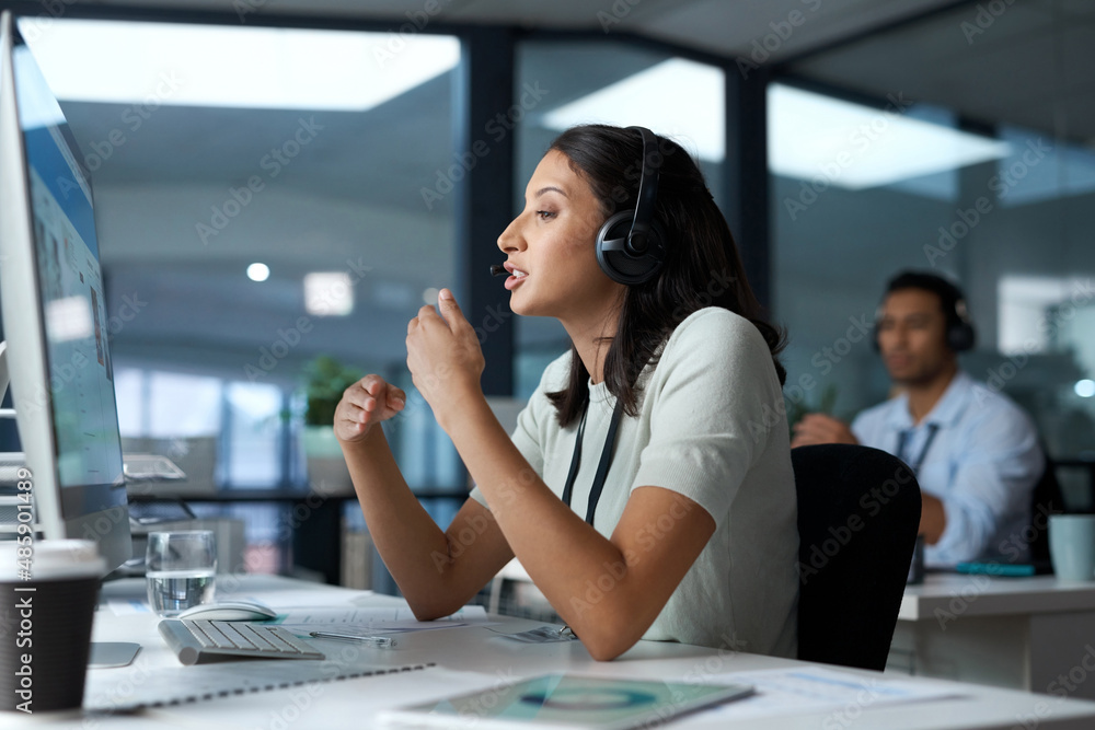 Poster hang in there, help is on the way. shot of a young woman using a headset and computer in a modern of