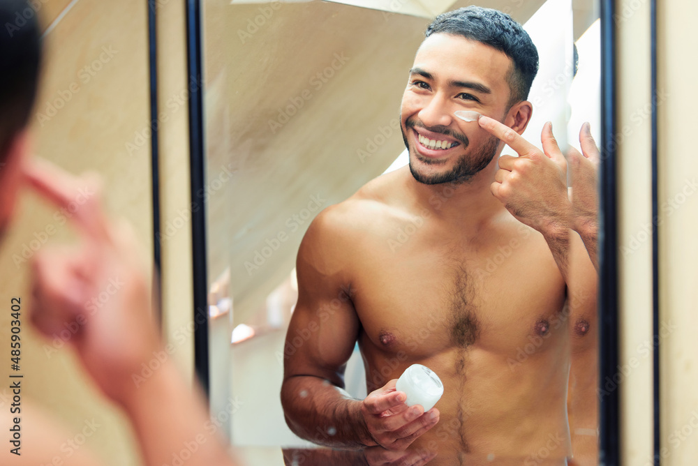 Poster he who moisturises has no regrets. shot of a handsome young man looking in the mirror while applying