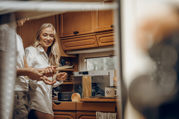 Young girl,guy just married couple,lovers traveling in camper,house on wheels,trailer,motor home.Love romantic road travel,freedom life.Small van kitchen,cooking.Wanderlust vacation,adventure weekend