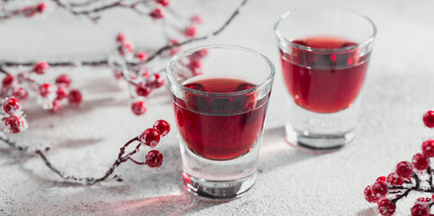 Two glasses of red cocktail, vodka or liqueur on light background