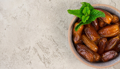 Dried dates lie in a gray bowl