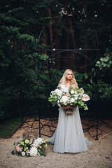 Obraz na płótnie Canvas Gorgeous blondie bride in perfect wedding dress posing with big wedding boquet.