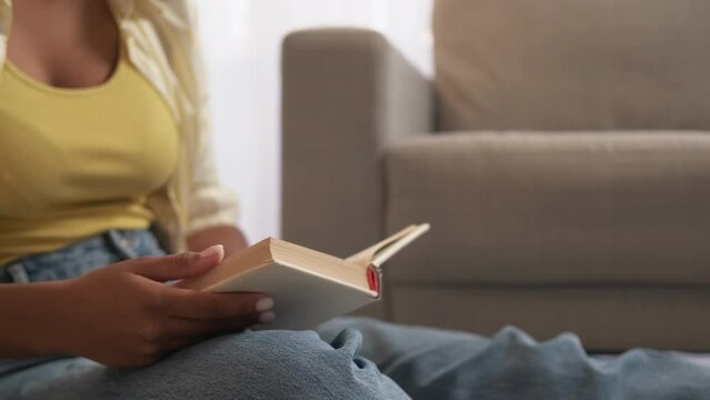 Book knowledge. Literature education. Library leisure. Unrecognizable woman reading bestseller novel story at home living room copy space.