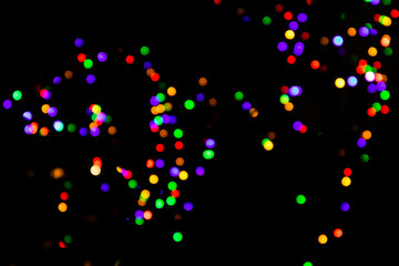 Multicolored garland on a dark background. Photo in the bokeh style.