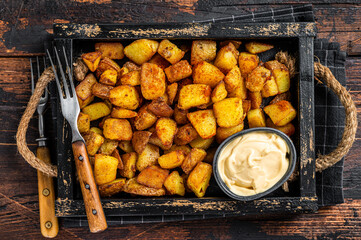 Patatas bravas traditional Spanish potatoes snack tapas. Dark wooden background. Top view