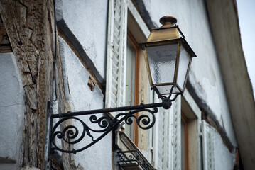 Closeup of retro street light on medieval house facade in the street