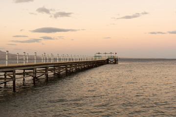 Fototapeta na wymiar Golden sea sunset on the wooden pier.
