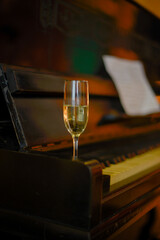 a glass of champagne stands on the piano. High quality photo
