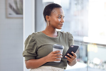 The internet is my link to world out there. Shot of a businesswoman drinking coffee and using her cellphone while looking out her office window.