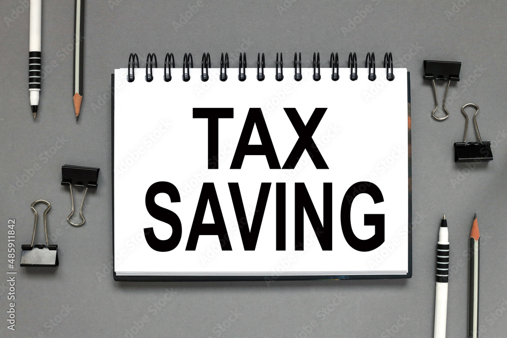 Poster tax saving open notepad with text on gray background. business concept