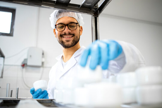 Close up view of pharmaceutical worker technologist working in cosmetics factory with healthcare creme products.