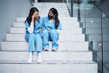 We did our best back there. Shot of a female nurse comforting her colleague while sitting on a staircase at work.