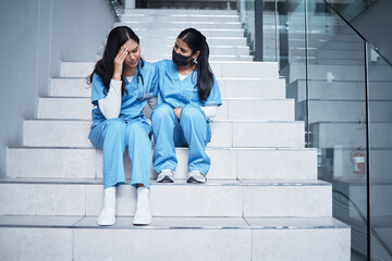 We did our best back there. Shot of a female nurse comforting her colleague while sitting on a...