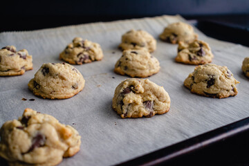 Soft-Batch Cream Cheese Chocolate Chip Cookies: Chocolate chip cookies on a sheet pan lined with parchment paper