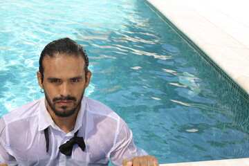 Seductive elegant ethnic man in swimming pool