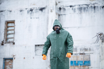 Fototapeta premium A man in a protective mask and protective clothing explores a dangerous radioactive area.